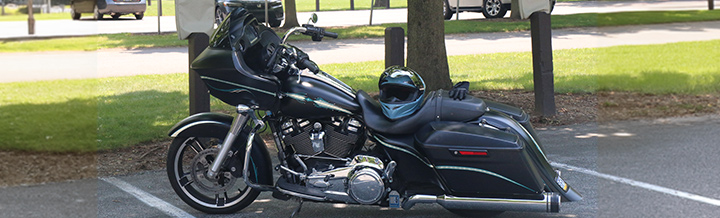 black classic cruiser parked in front of a tree