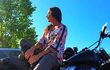 Motorcycle rider Raven sitting on her motorcycle