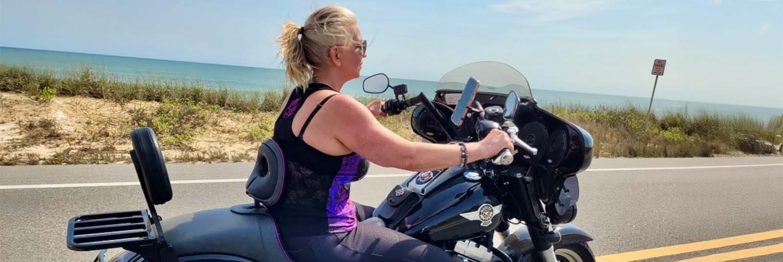 Rider riding motorcycle down coastal road