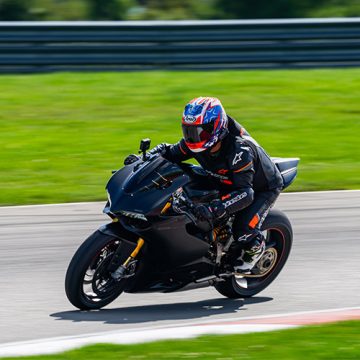rider-new-hero-mobile motorcycle rider on a road riding with black gear on and a red helmet